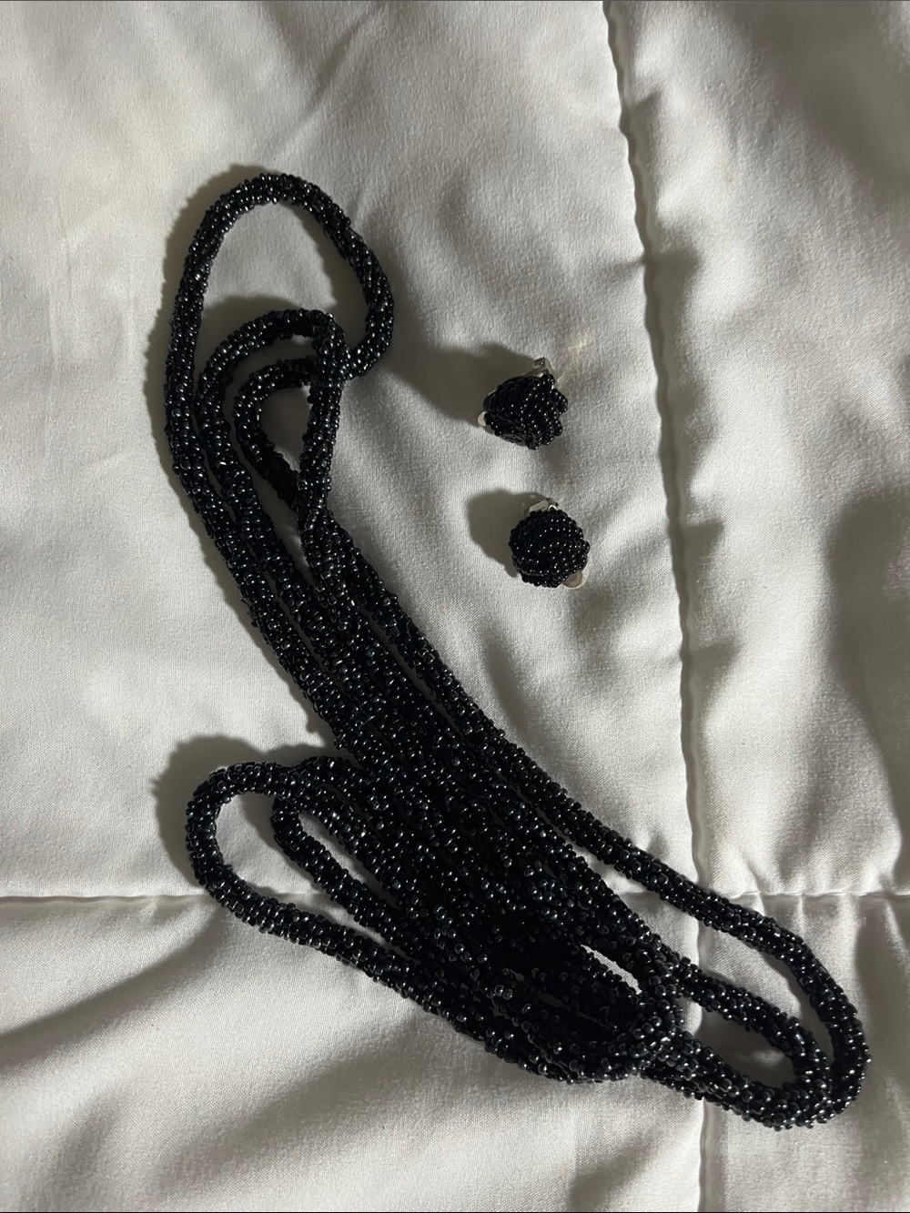 Black shinny beaded necklace with clip earrings.